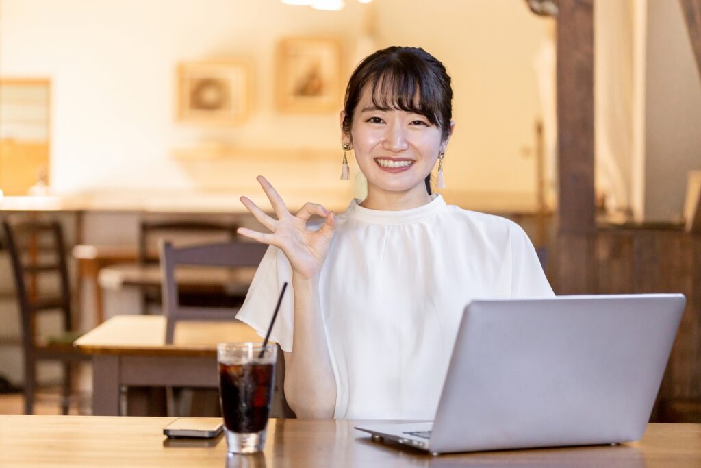 右手でOKサインをしている女性