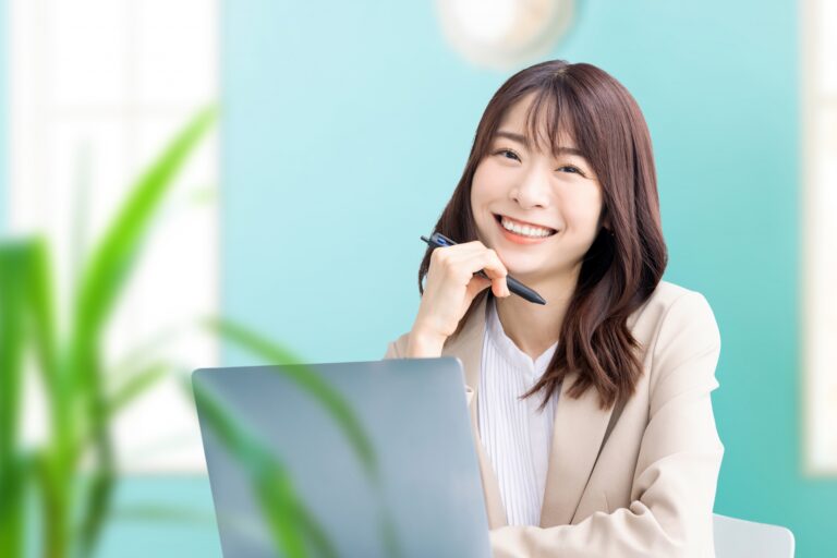 パソコン前で笑顔の女性