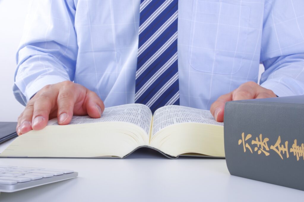 六法全書を読むスーツの男性