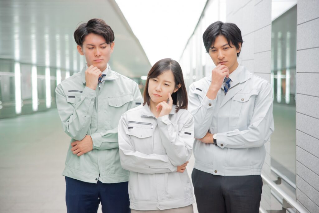 考える作業服の男女
