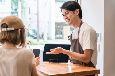 タッチ決済に対応する店員