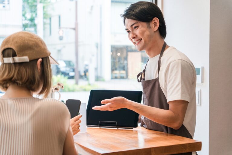 タッチ決済に対応する店員