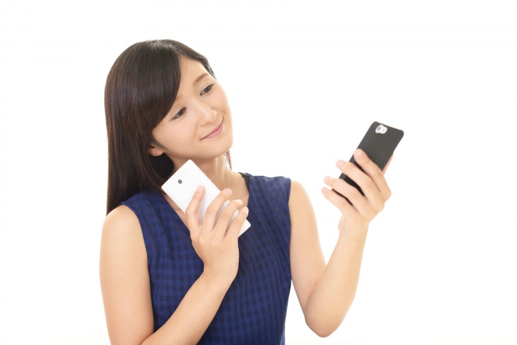 2台のスマホを比較する女性