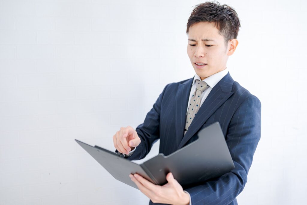 書類を見て厳しい表情をするビジネスマン