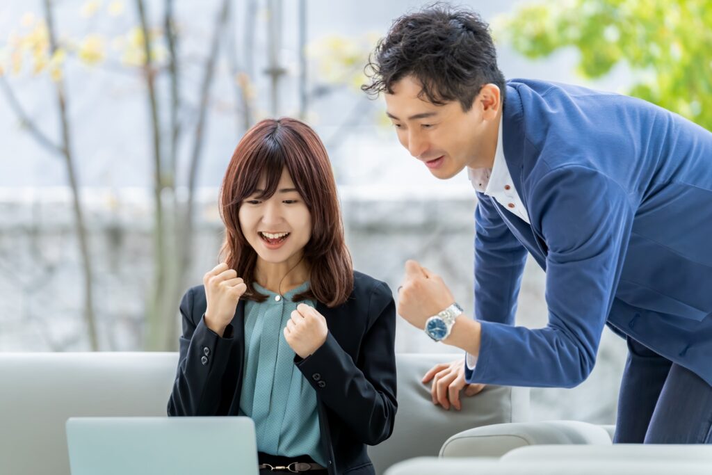 パソコン画面を見て喜ぶ男女