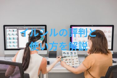 2人の女性がパソコン作業中に相談している