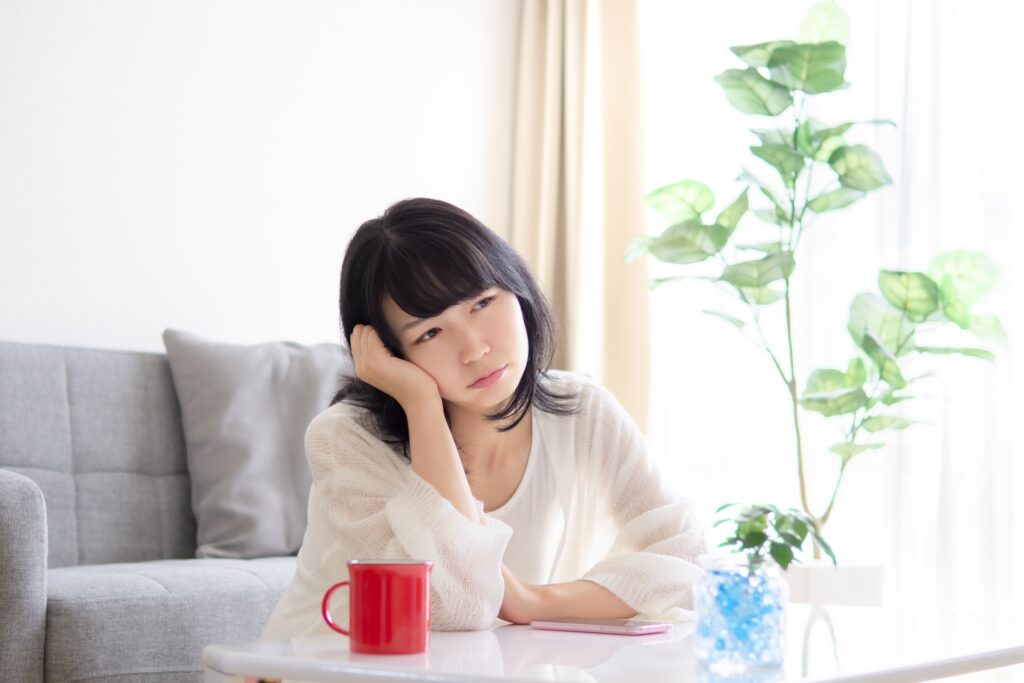 肩肘をついて悩む女性