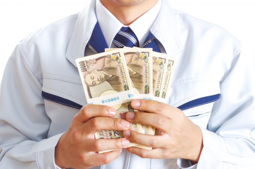 大金を手に持つ作業服の男性