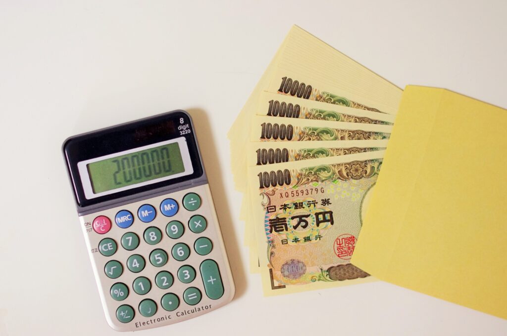 電卓に表示されている200,000の数字と封筒に入っている20万円のお金 