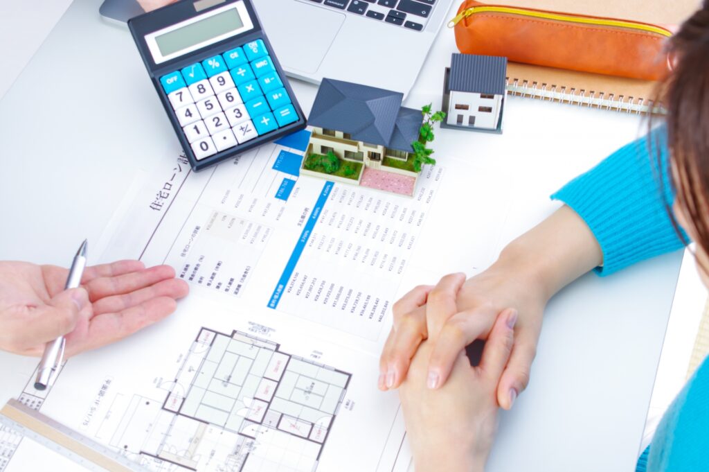 マイホームの話をする男女。返済シミュレーション表と電卓