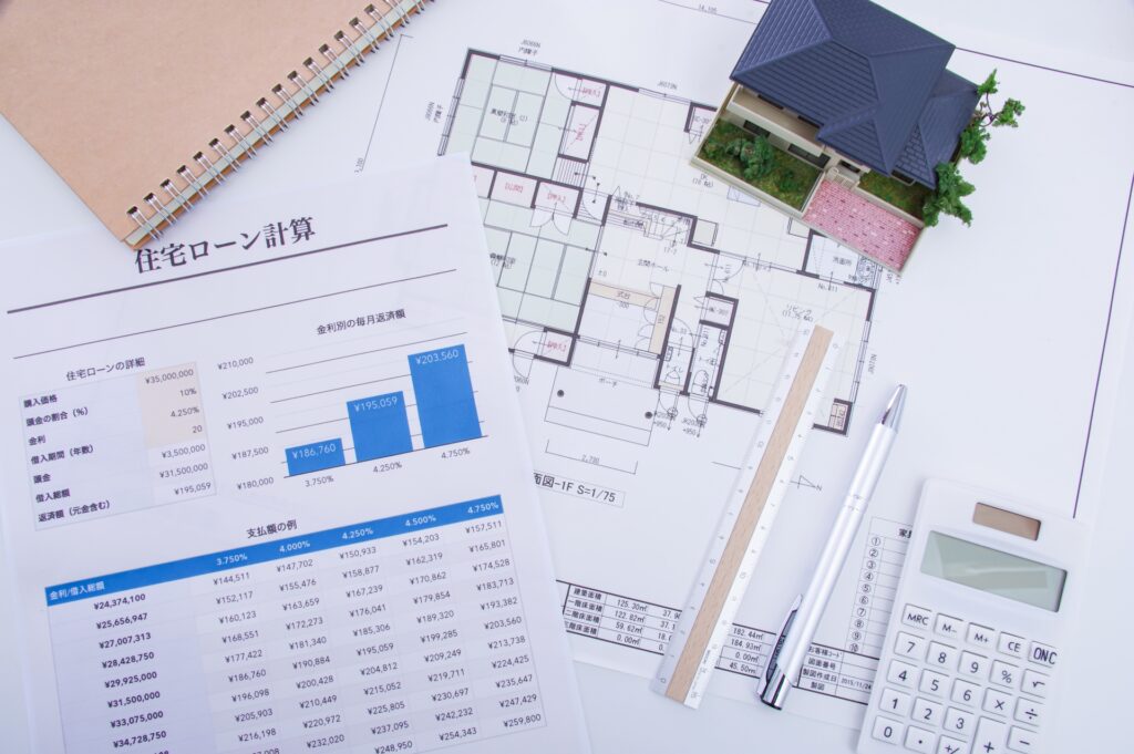 家の模型と、住宅ローン返済計画表