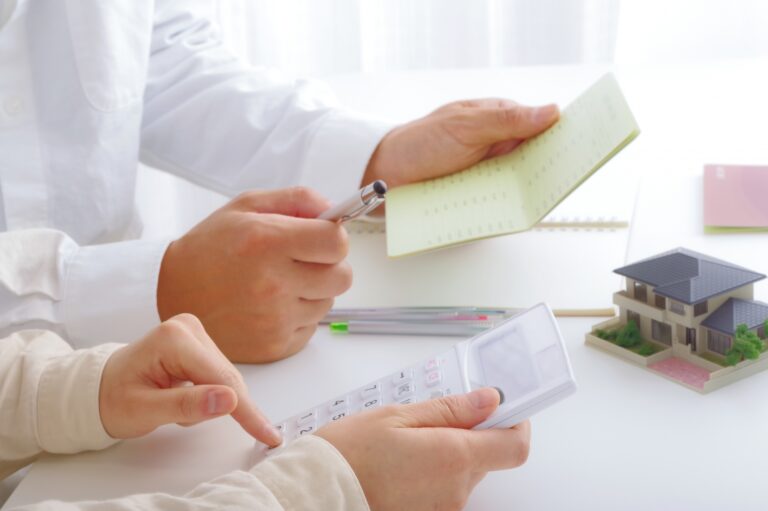 夫婦が通帳と電卓をもって借り換えローンの話し合いをしている