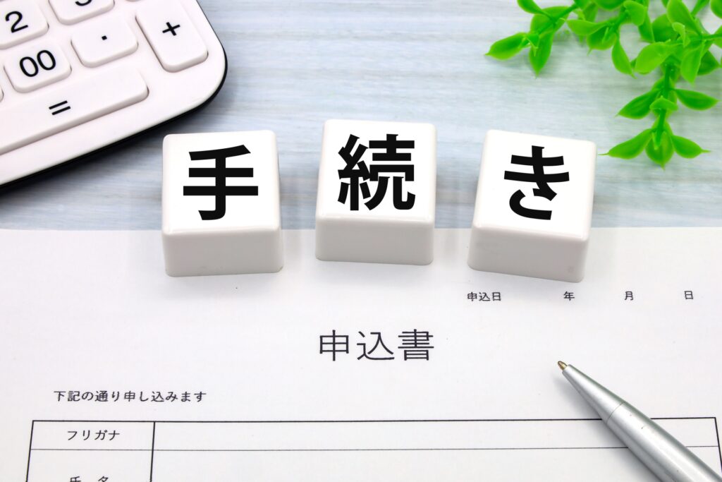 手続きの文字と申込書とボールペンのイメージ画像