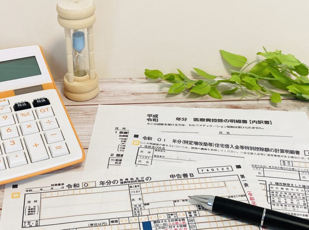 確定申告関連の書類と電卓と砂時計