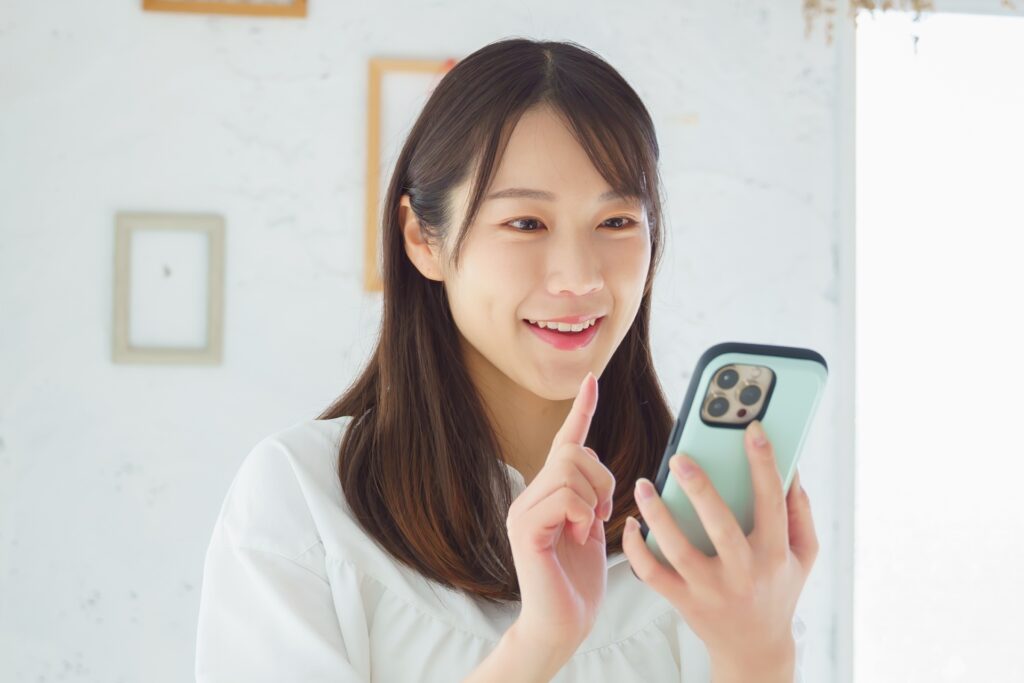 笑顔でスマホを操作する女性