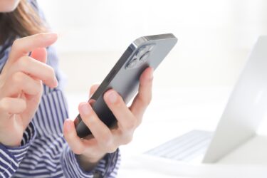 スマホをタップしようとしている女性