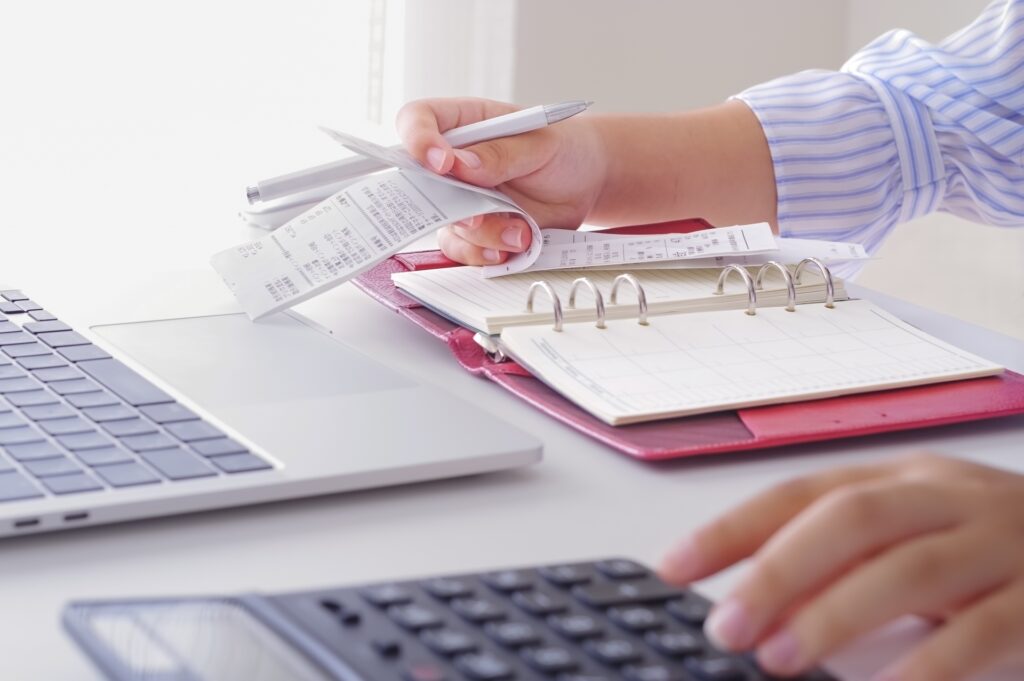 領収証の金額を電卓で計算している