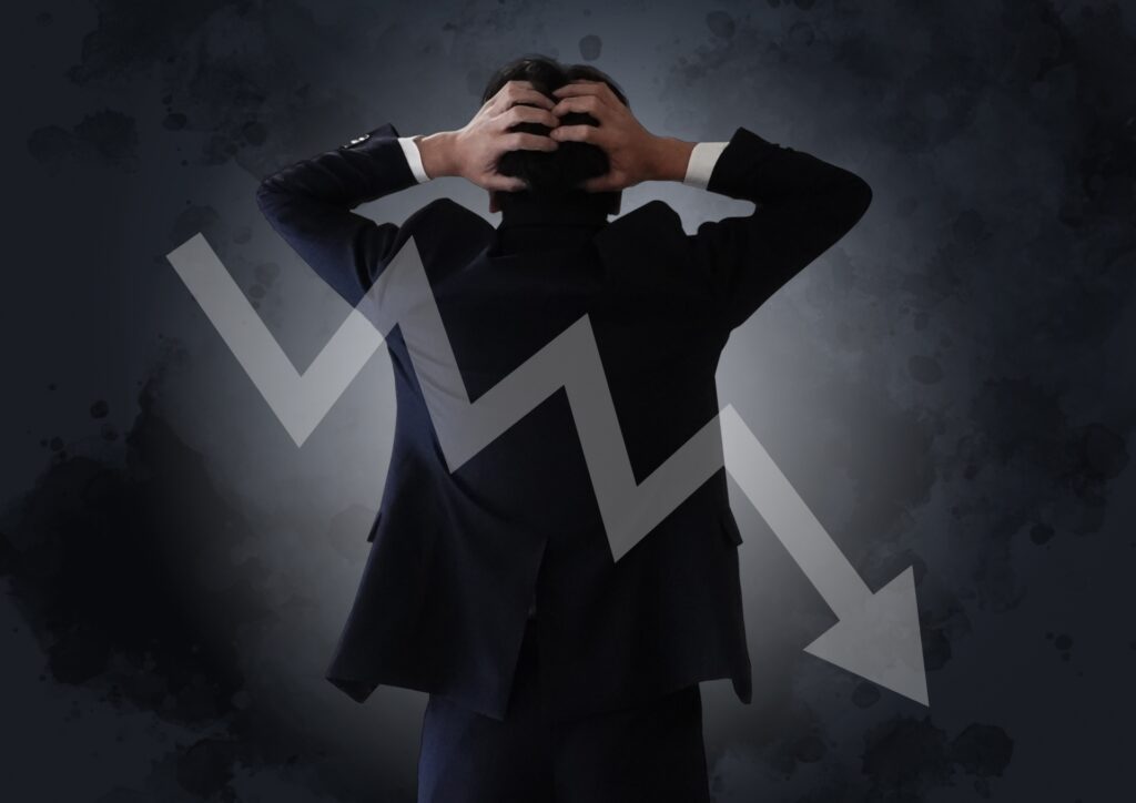 頭を抱える後ろ姿の男性