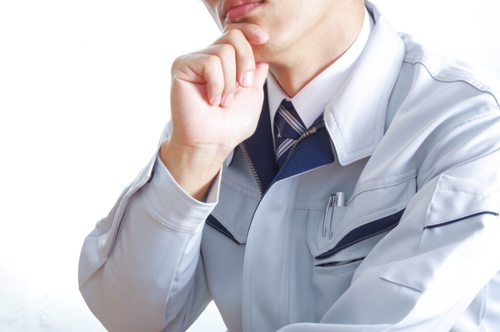 考える作業着の男性