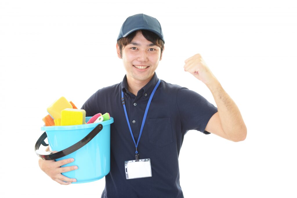 笑顔でガッツポーズする男性清掃員