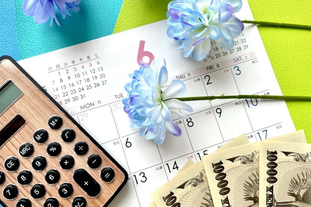 6月のカレンダーと電卓とお金の画像